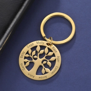 Close-up of golden tree of life keychain with custom laser engraved names on round pendant