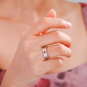 Silver clover cutout wide band ring in matte finish on model hand close-up