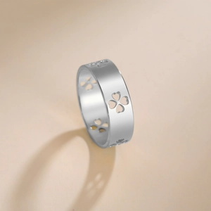 Silver wide band heart clover cutout ring in stainless steel on minimalist background