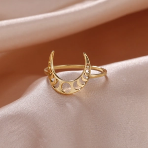 Anello a mezzaluna in oro lucido con motivi a traforo su sfondo di seta rosa