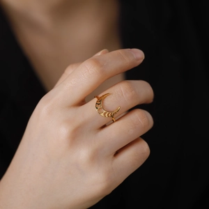 Dettaglio di un anello a mezzaluna placcato in oro con design delle fasi lunari