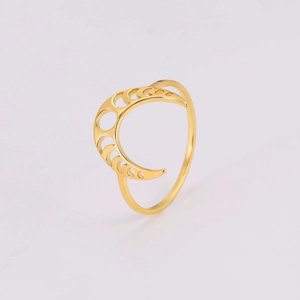 Dettaglio di un anello a mezzaluna dorato con motivi circolari traforati incisi