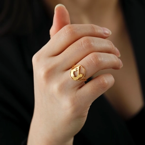 Golden stainless steel ring with hollow circular map design worn by a model