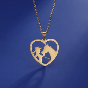Collana con cuore dorato e sagoma di ragazza e cavallo su sfondo blu scuro intenso