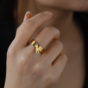 Polished 18K gold plated stainless steel ring with a small boy silhouette pendant charms