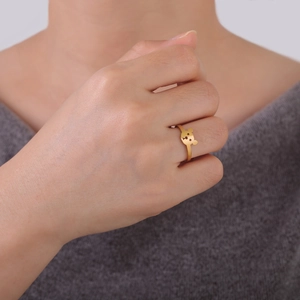 Gros plan d'une bague ours dorée épurée portée au doigt avec des finitions précises