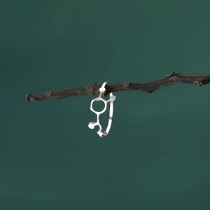 Close-up of a silver chemical molecule ring hanging on a natural tree branch