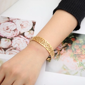 Celtics knot cuff bangle in 18K gold plated stainless steel on a female wrist