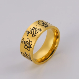 Macro detail of 8mm gold stainless steel ring featuring etched animal patterns like bees and birds