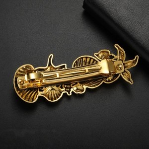 French vintage gold zinc alloy hair clip with starfish and seashell charms on black texture