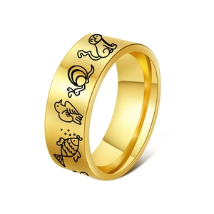Macro detail of 8mm gold stainless steel ring with black etched animal cartoon patterns