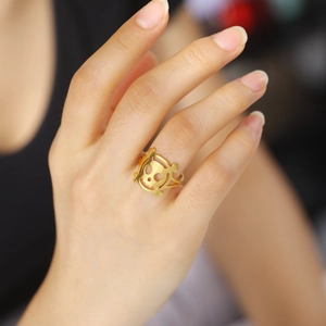 Close-up of golden hollow skull and crossbones ring on finger for a stylish streetwear look