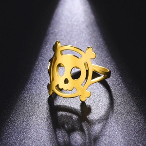 Detailed macro shot of a hollow gold pirate skull ring with gothic punk metal texture
