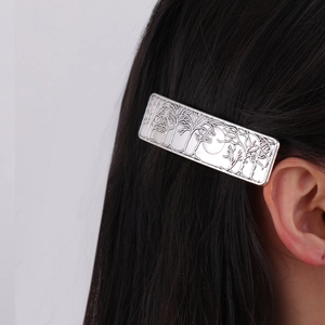 French vintage silver hair clip with forest moon relief shown on a model's hair