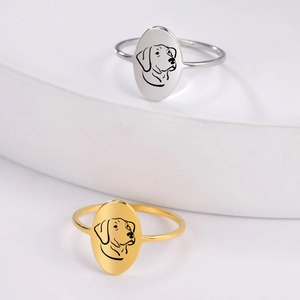 Detailed close-up of 18K gold and silver oval rings featuring laser engraved dog outlines