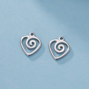 Vista macro di ciondoli a cuore a spirale in acciaio inossidabile lucido per gioielli DIY