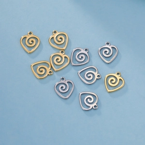 Dettaglio di ciondoli a cuore con spirale dorati e argentati per creazione gioielli DIY