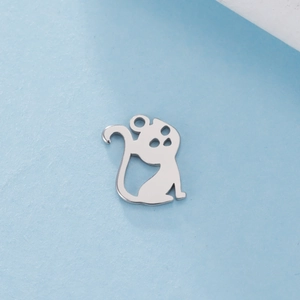 Gros plan d'un pendentif chat argenté évidé avec un design à longue queue