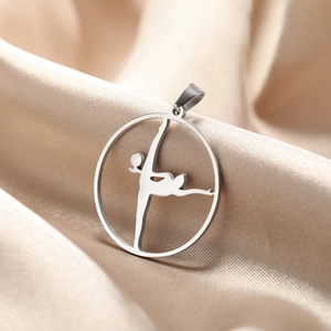 Detailed macro view of a polished stainless steel rhythmic gymnastics pendant on silk cloth