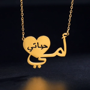 Collana con ciondolo a cuore dorato e calligrafia araba su sfondo nero opaco