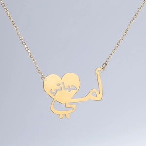 Dettaglio della collana a cuore in acciaio inossidabile dorato con calligrafia araba