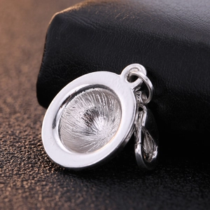 Polished silver zinc alloy helmet pendant with lobster clasp on black background