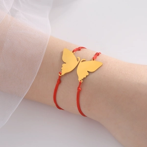 Red braided rope bracelet with gold butterfly charms on a woman's wrist