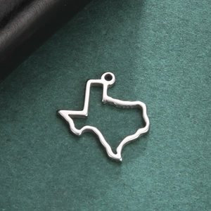 Minimalist stainless steel Texas map pendant with hollow-out design on green background