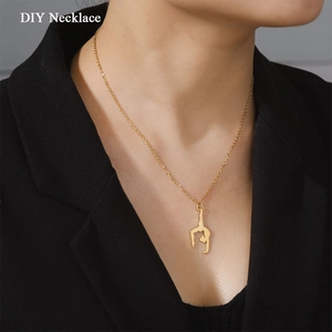 Détail d'un collier doré avec pendentif de gymnaste sur un blazer noir
