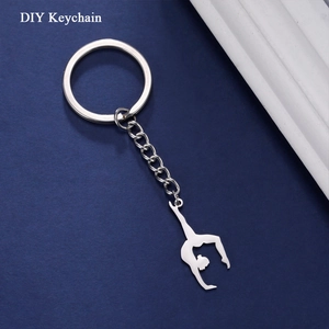 Porte-clés avec pendentif silhouette gymnaste en acier inoxydable sur fond bleu texturé