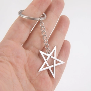 Polished stainless steel inverted pentagram keychain charm held by hand on white background