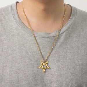 Detail of a gold stainless steel hollow star pendant necklace worn by a model