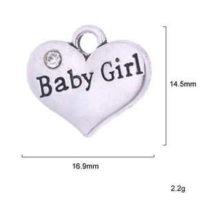 Détail d'un pendentif cœur argenté avec gravure Baby Girl et petit cristal brillant