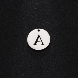 Nahaufnahme eines runden Edelstahl-Anhängers mit schwarz graviertem Buchstaben A in Silber