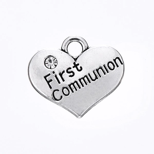 Détail macro du pendentif coeur argenté avec gravure First Communion et un petit strass