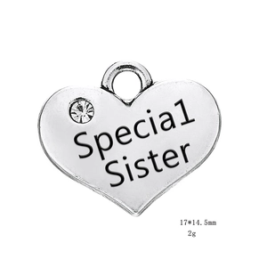 Gros plan détaillé d'un pendentif en cœur avec gravure Special Sister et petit strass
