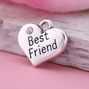 Détail macro d'un pendentif cœur en alliage avec gravure Best Friend et un zircon