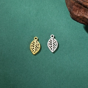 Pendentif feuille évidée en or et argent sur un fond naturel texturé pour bijoux DIY