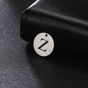 Makroaufnahme eines 12mm runden Edelstahlanhängers mit Buchstabe Z auf Lederhintergrund