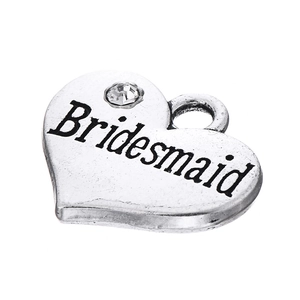 Détail d'un pendentif cœur vintage avec gravure 'Bridesmaid' et un petit strass brillant