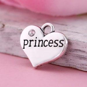 Vue macro détaillée d'un pendentif cœur argenté avec gravure princess et petite zircone