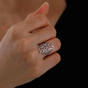 Polished silver titanium steel ring with hollow mandala pattern shown on finger