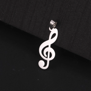 Polished silver stainless steel G-clef musical note pendant close-up on black fabric
