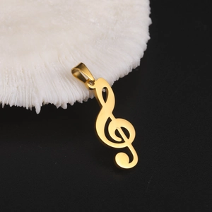 Close-up of golden treble clef music note pendant with polished mirror finish