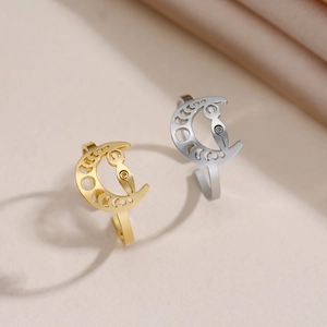 Detail of hollow moon phase open rings in gold and silver with owl head motifs