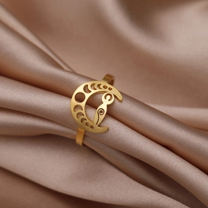 Gold hollow moon phase spiral ring in stainless steel on champagne silk background