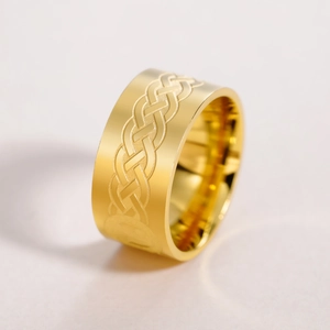 Detailed macro view of a 10mm wide golden stainless steel ring with Celtic weave engraving