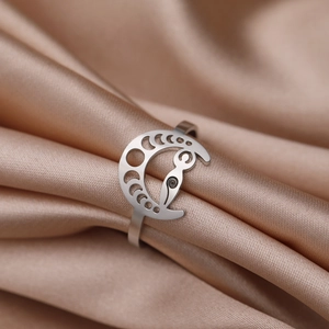 Silver stainless steel moon phase ring featuring cut-out goddess symbol on satin silk