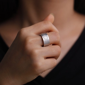 Macro shot of 10mm wide stainless steel ring with Celtic knot patterns on a finger