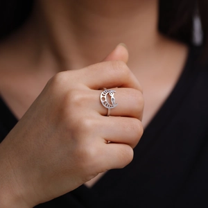Adjustable silver moon ring with hollow spiral pattern on a finger in high quality macro view